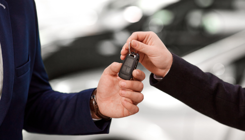 homme qui donne les clés d'une voiture à quelqu'un